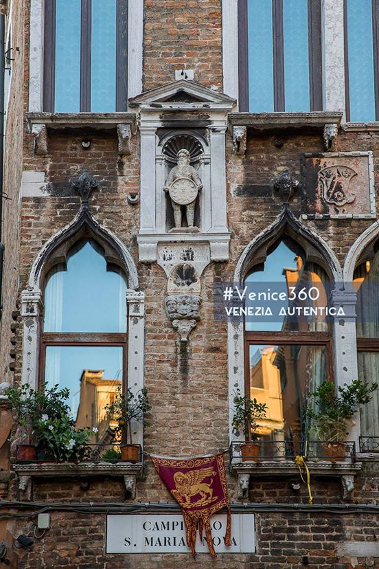 The Statue of the Homo Selvaticus on the Palazzo Bembo Boldù in Venice. The statue shows a hairy man holding a solar disk