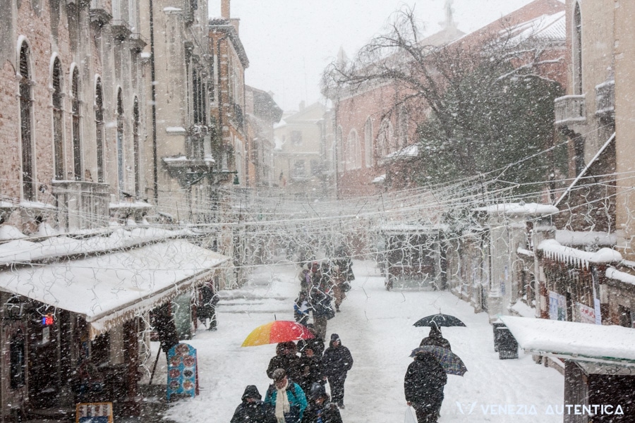 People living in Venice moving around by foot on a cold and snowy winter day.