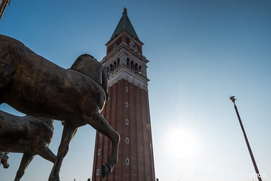 Campanile di San Marco or Saint Mark's Bell Tower in Venice, Italy. View from the Saint Mark's basilica terrace, with the horses of Saint Mark in the foreground.