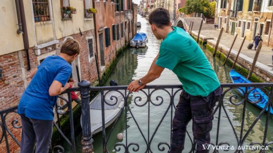 Children retrieving their football from a canal in Venice, Italy