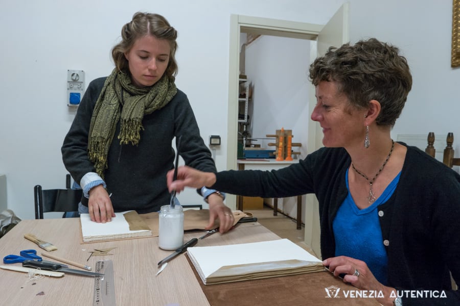 Two people learning the ancient art of bookbinding in Venice